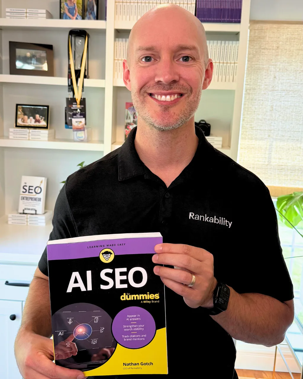 Nathan Gotch holding a copy of AI SEO For Dummies